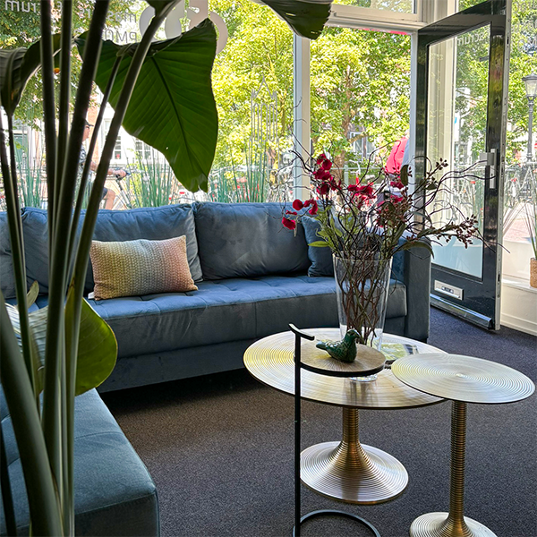 Interieur bij de C5 Groep, blauwe bank, gouden tafeltjes en uitzicht Oudegracht Utrecht
