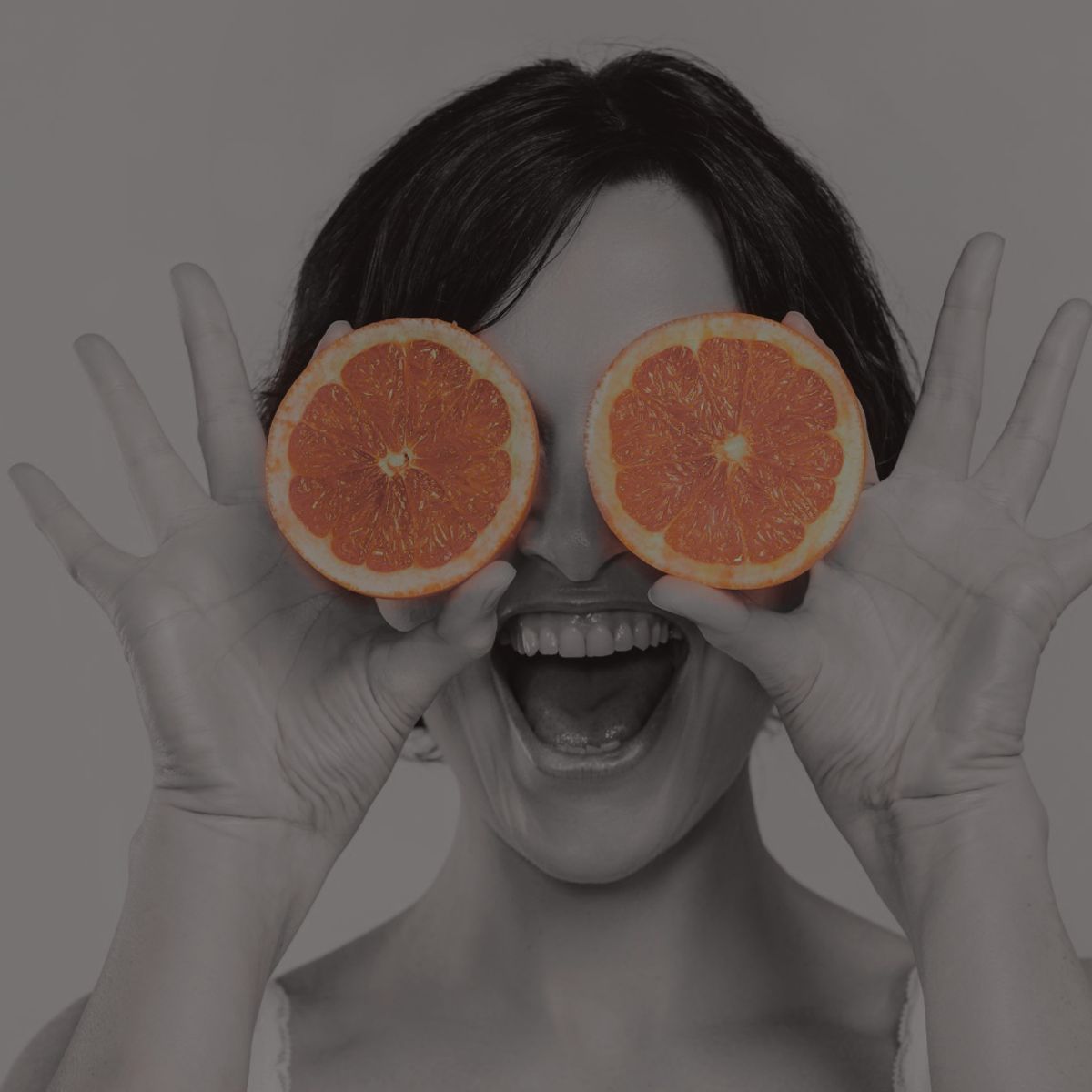 Een vrouw met oranje sinaasappels voor haar ogen